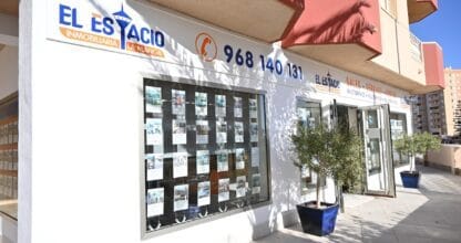 Oficina de Inmobiliaria El Estacio La Manga con escaparate lleno de propiedades en venta