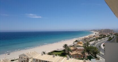 Vista panorámica desde Inmobiliaria Mavina de la playa de La Manga del Mar Menor con aguas turquesas y paseo marítimo