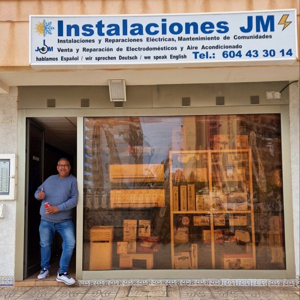 Fachada de Instalaciones JM en La Manga del Mar Menor, local de electricidad y electrodomésticos con hombre posando en la entrada