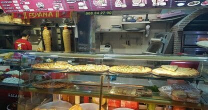 Interior de King Kebab en La Manga del Mar Menor con mostrador de pizzas y espetos de shawarma con carta en árabe y español