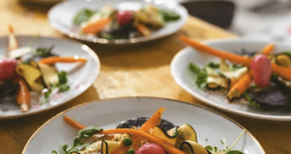 Platos de catering de La Birdie Catering con verduras y guarniciones coloridas servidos en platos blancos