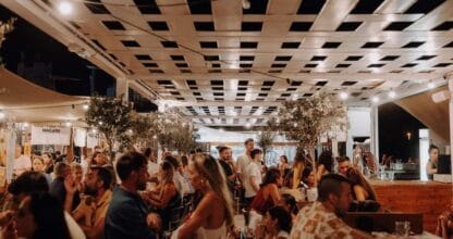 La Fresca Gastromercado llena de gente en La Manga del Mar Menor, ambiente nocturno festivo bajo luces y árboles interiores