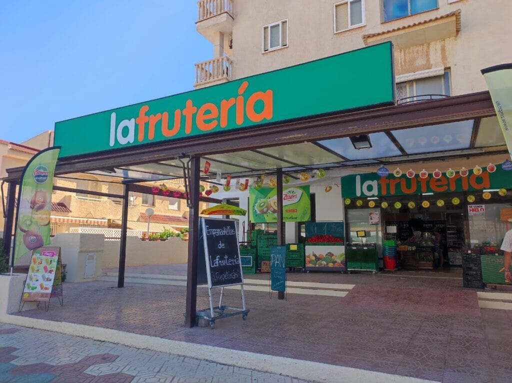 Fachada exterior de La Frutería en La Manga del Mar Menor con gran rótulo verde, frutas y verduras frescas expuestas en la entrada