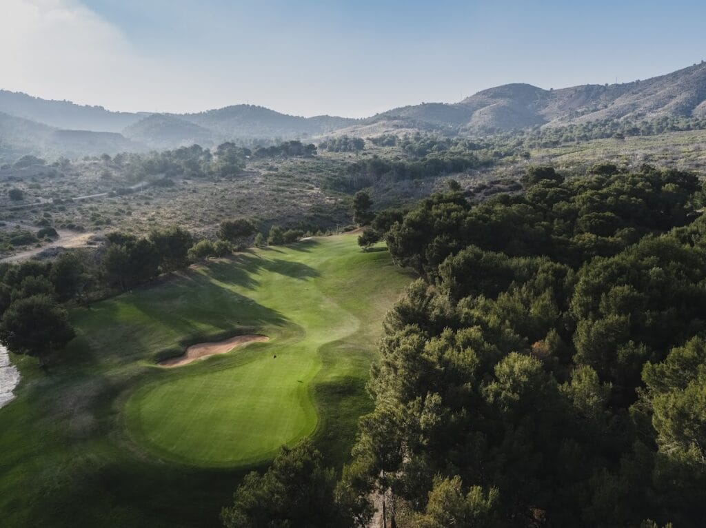Vista aérea del fairway con bunker de arena y pinos del Campo Oeste de La Manga Club, La Manga del Mar Menor