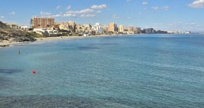Vista panorámica de la costa de La Manga del Mar Menor con aguas turquesas y edificios residenciales al fondo