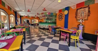 Interior colorido del restaurante La Rodaja en La Manga del Mar Menor, decoración mexicana con sombreros, sillas multicolor y suelo a cuadros