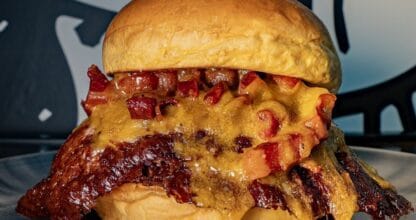 Hamburguesa XXL con bacon crujiente y queso fundido en plato de acero en Lacy La Manga