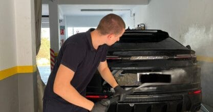 Operario lavando con hidrolimpiadora un Lamborghini negro en el interior del Lavadero Mar Menor