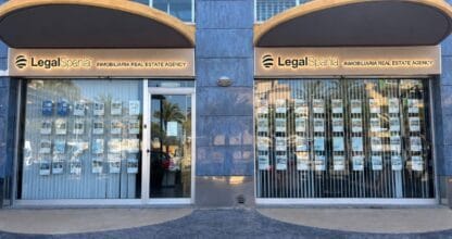 Fachada de dos locales de LegalSpania inmobiliaria con escaparates de propiedades en La Manga del Mar Menor