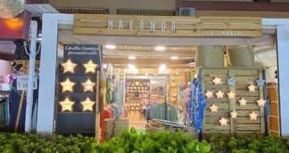 Fachada nocturna de Makondo La Manga, tienda de ropa y recuerdos decorada con estrellas luminosas y cajas de madera
