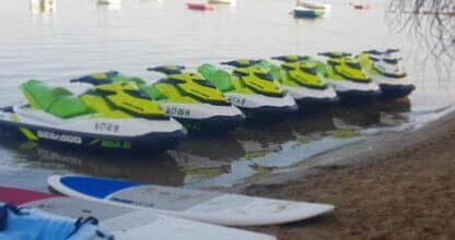 Flota de motos acuáticas Sea-Doo amarillas y verdes alineadas en la orilla, alquiler Maleni Jet en La Manga del Mar Menor