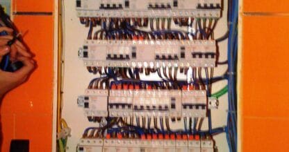 Cuadro eléctrico de distribución con múltiples interruptores diferenciales y cableado multicolor, trabajo de instalación eléctrica profesional
