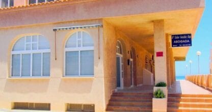 Fachada del despacho de la abogada María Esthér González Rája en La Manga del Mar Menor con acceso porticado junto al paseo marítimo
