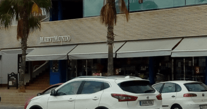 Edificio del centro comercial Coco de Mer en La Manga del Mar Menor con palmeras y aparcamiento en primer plano