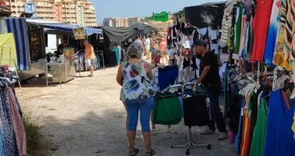 Puestos de ropa del Mercadillo de La Manga con visitantes paseando entre los tenderetes al aire libre