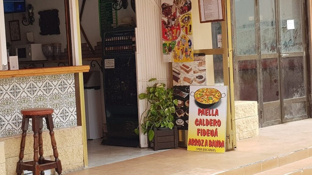 Entrada del Mesón Andaluz de Antonio con cartel de paella, caldero, fideuá y arroz a banda por encargo