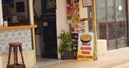 Entrada del Mesón Andaluz de Antonio con cartel de paella, caldero, fideuá y arroz a banda por encargo