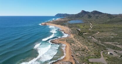 Vista aérea de la costa virgen desde el Mirador de Punta Negra con playa de arena y monte mediterráneo