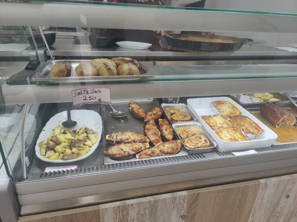 Vitrina de comidas caseras con berenjenas al horno, lasaña, salteñas y patatas en Mr. Tasty, La Manga del Mar Menor