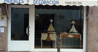 Escaparate de Muebles y Decoración Pino Decor en La Manga del Mar Menor con mesas antiguas, lámparas y maquetas de veleros decorativas