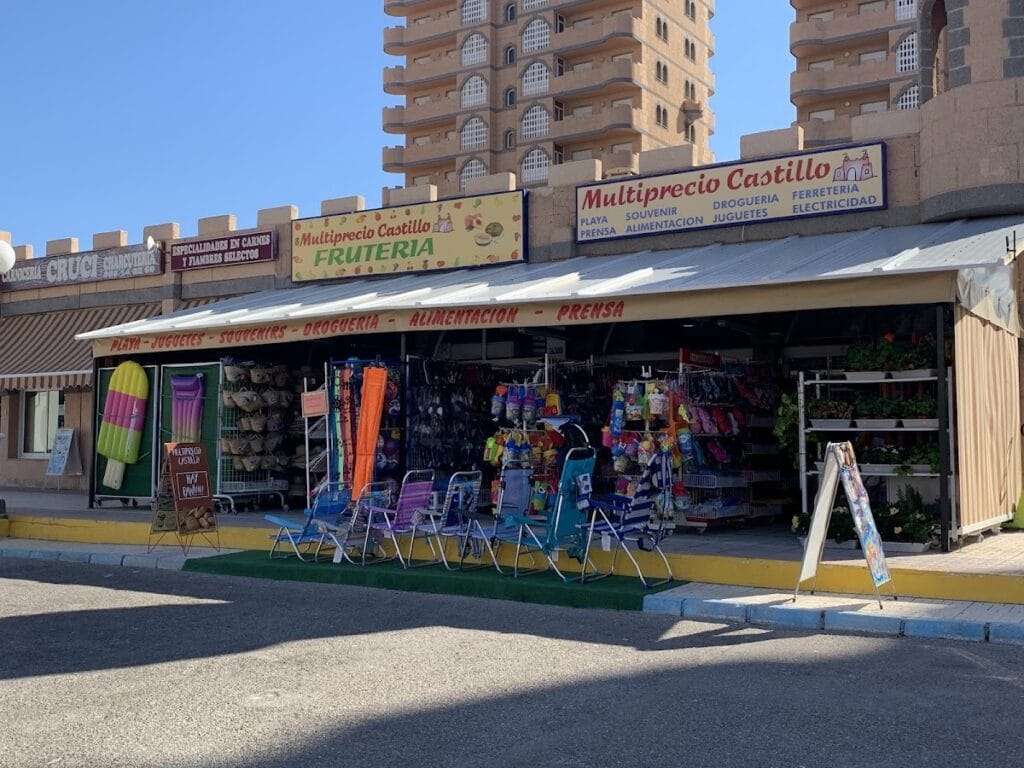 Fachada amplia de Multiprecio Castillo en La Manga del Mar Menor con frutería, sillas de playa y productos de droguería expuestos
