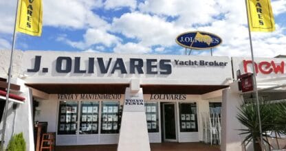 Local de J. Olivares Yacht Broker con banderas amarillas y rótulo de venta y mantenimiento náutico
