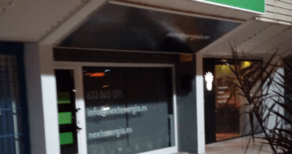Fachada de la oficina NEXT Energía con rótulo luminoso y escaparate en La Manga del Mar Menor