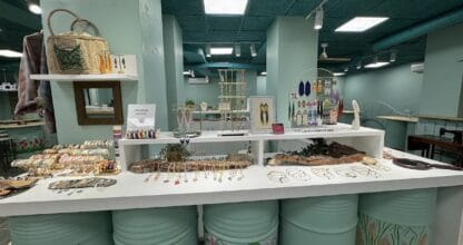Interior de Nüa Shop Bisutería con mostrador decorado con barriles pintados y amplia exhibición de collares, pulseras y pendientes artesanales