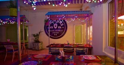 Terraza de Paimans Asian Street Food decorada con luces de colores y mesas preparadas, La Manga del Mar Menor