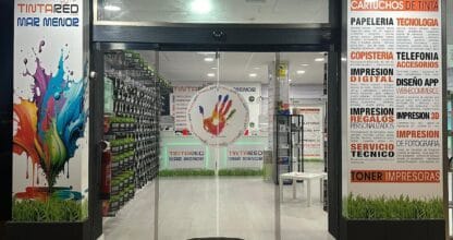 Fachada iluminada de noche de Papelería Copistería TintaRed Mar Menor con escaparate de cartuchos y servicios de impresión