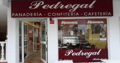 Fachada del Pedregal Cafetería Confitería Heladería en La Manga con gran rótulo granate, logo Jijonenca en escaparate y sillas rojas en la acera