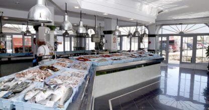 Pescadería Pescados Cabo de Palos I con expositores de pescado fresco y marisco sobre hielo bajo lámparas industriales de acero