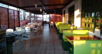 Terraza cubierta de Pizzería Da Sebastián en La Manga del Mar Menor con booths verdes y sillas blancas de plástico