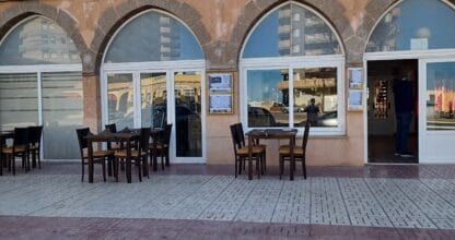Fachada exterior de Pizzería Old Italy en La Manga del Mar Menor, con arcos de piedra y terraza con mesas en la calle