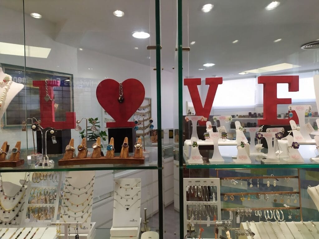 Escaparate de Platería Nün en La Manga del Mar Menor con anillos, collares y pendientes de plata expuestos en vitrinas de cristal