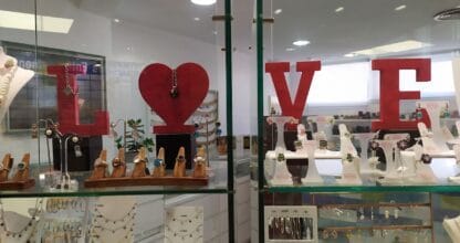 Escaparate de Platería Nün en La Manga del Mar Menor con anillos, collares y pendientes de plata expuestos en vitrinas de cristal