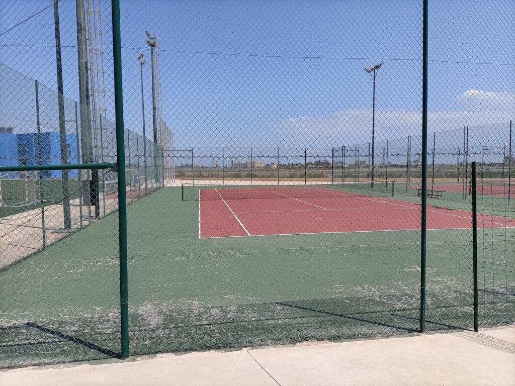 Pista de tenis al aire libre con suelo rojo y verde en el Polideportivo Playa Paraíso, La Manga del Mar Menor