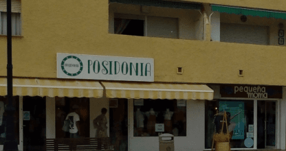Fachada amarilla de Posidonia La Manga, tienda de moda en paseo comercial peatonal de La Manga del Mar Menor