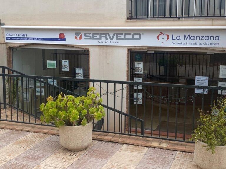Local comercial en La Manga Club Resort con rótulos de Quality Homes, Serveco Solicitors y La Manzana Cohousing en la fachada