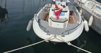 Lancha motora de Rent Boats Alicante decorada con globos de cumpleaños amarrada en el puerto deportivo junto a otros barcos