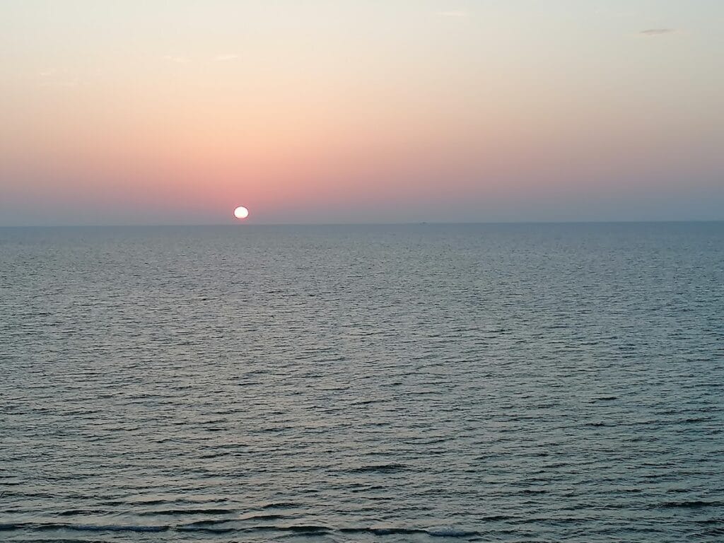 Atardecer sobre el Mar Menor con el sol rozando el horizonte y el agua en calma, vistas desde Residencial Segura