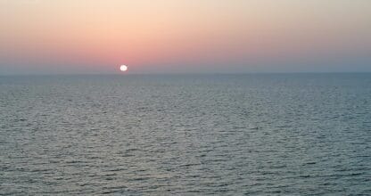 Atardecer sobre el Mar Menor con el sol rozando el horizonte y el agua en calma, vistas desde Residencial Segura