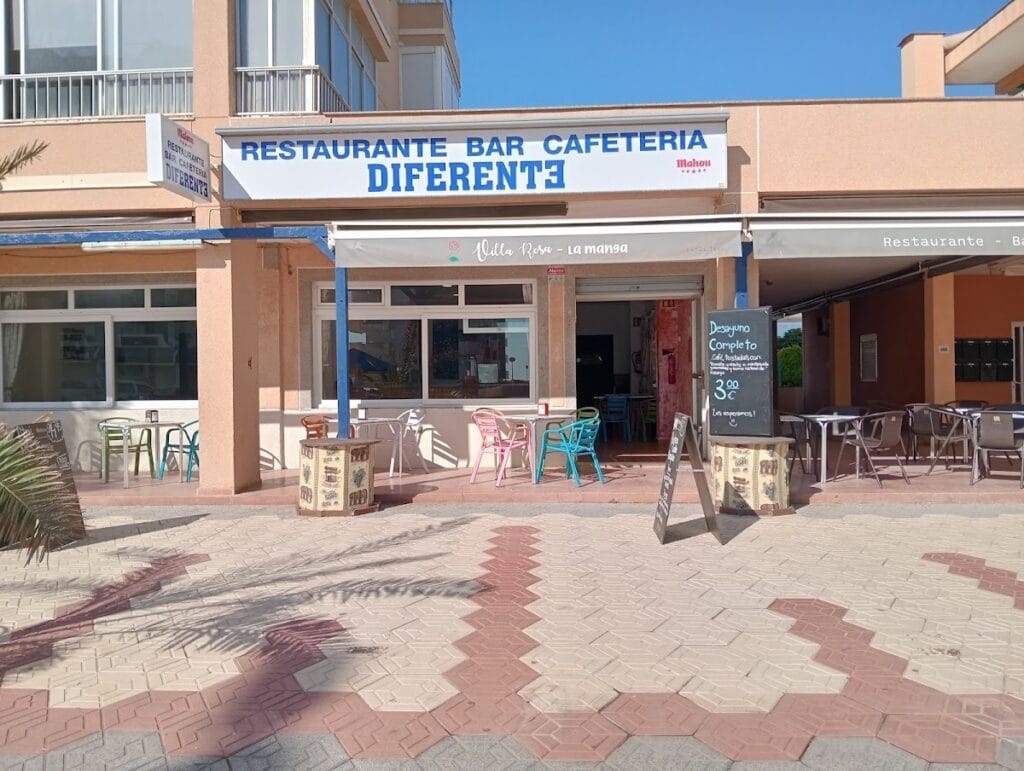 Terraza exterior del Restaurante Bar Cafetería Diferente con sillas de colores y pizarra de desayuno completo en La Manga
