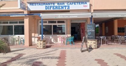 Terraza exterior del Restaurante Bar Cafetería Diferente con sillas de colores y pizarra de desayuno completo en La Manga