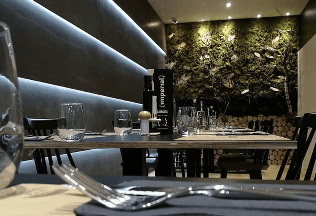 Sala interior con iluminación tenue y pared vegetal decorativa del Restaurante Imperial, La Manga
