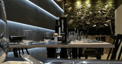 Sala interior con iluminación tenue y pared vegetal decorativa del Restaurante Imperial, La Manga