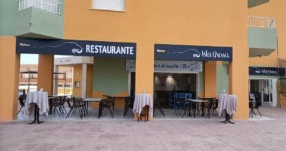 Fachada y terraza exterior del Restaurante Isla Grosa con mesas dispuestas en La Manga del Mar Menor