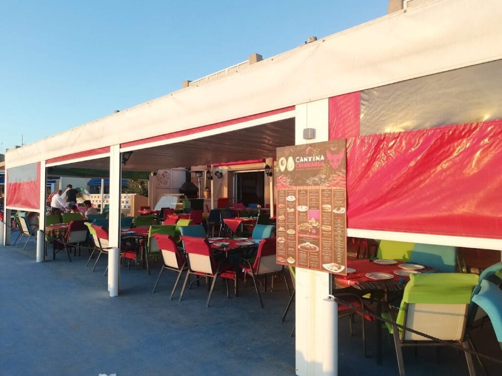 Terraza del Restaurante Mexicano Cantina Chihuahua en La Manga con sillas multicolor bajo carpa blanca y carta visible a la entrada