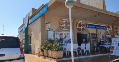 Fachada exterior de Restaurante Pizzería Venezia con rótulos de pescado, paella y carnes en La Manga