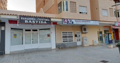 Fachada de RM Gestión Inmobiliaria junto a panadería Bastida en bloque residencial de La Manga del Mar Menor
